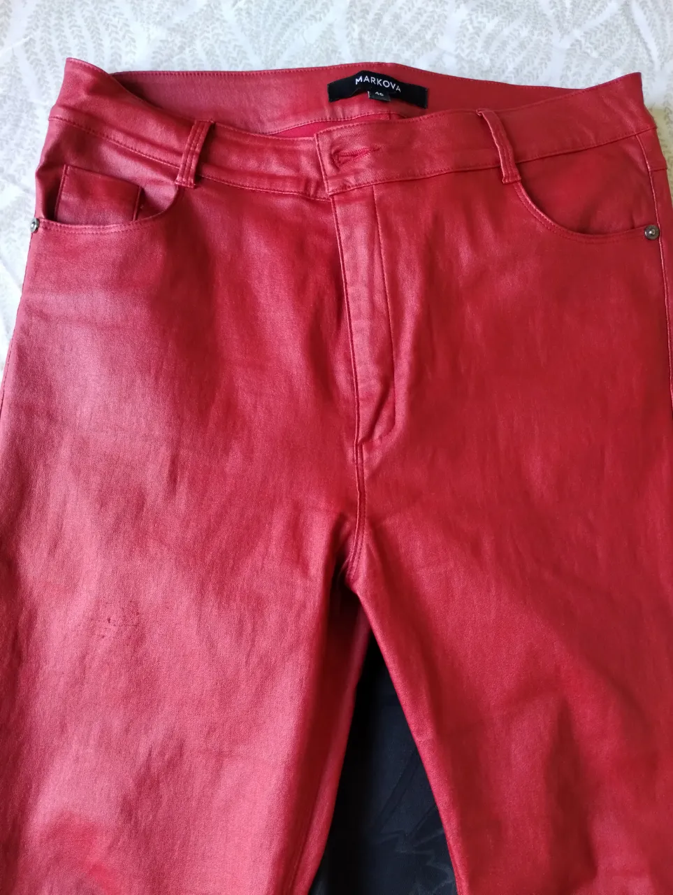 Pantalón de ecocuero engomado rojo, tiro alto, con bolsillos. Ideal para un look audaz y moderno. Usado bien cuidado. Color cereza (no rojo tan brillante)