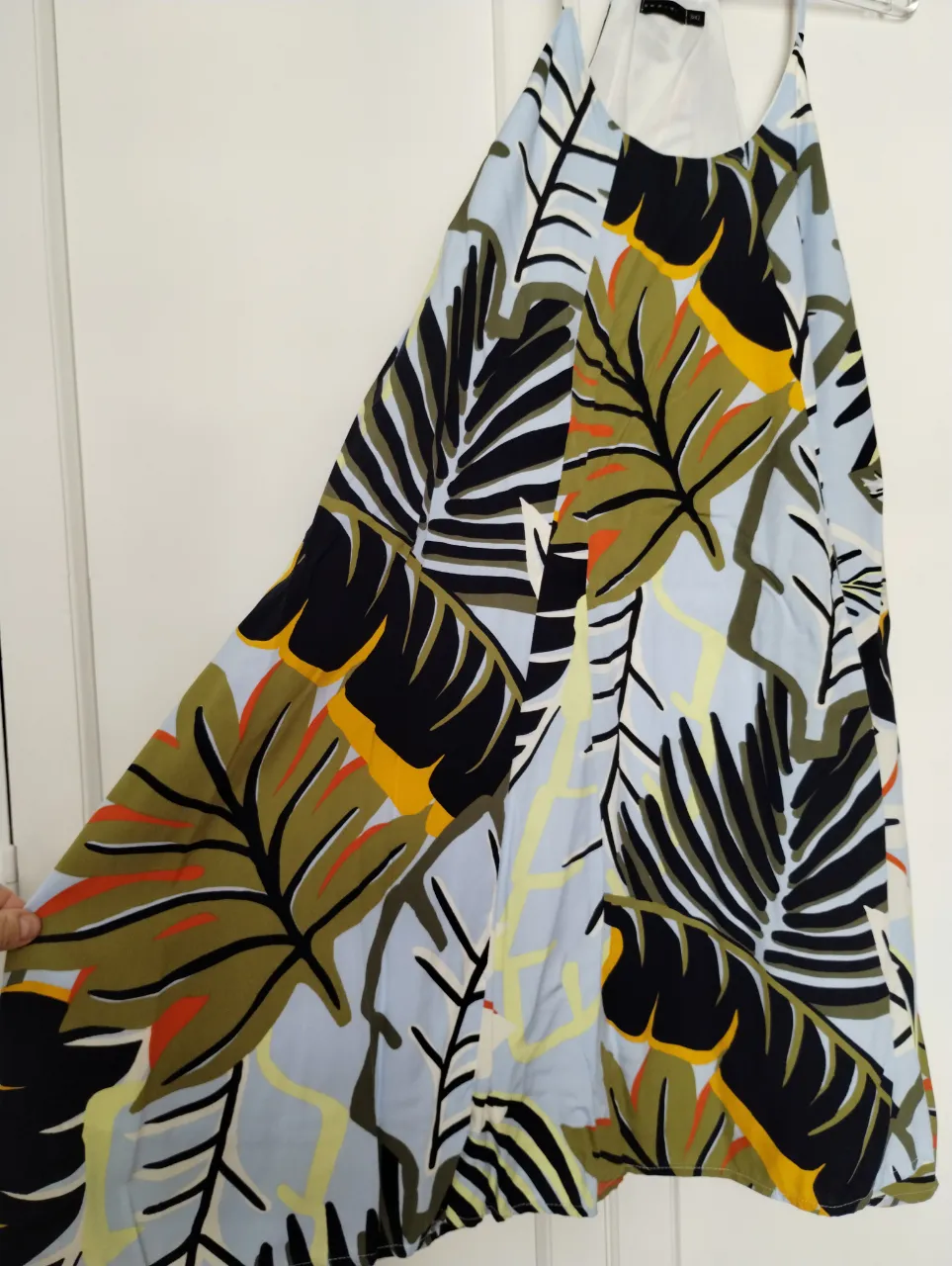 Vestido corto Swami con estampa de hojas tropicales en tonos azules, verdes, negros y detalles en naranja y amarillo. Ideal para un look fresco y playero. talle 3 o 42 amplio sin uso.