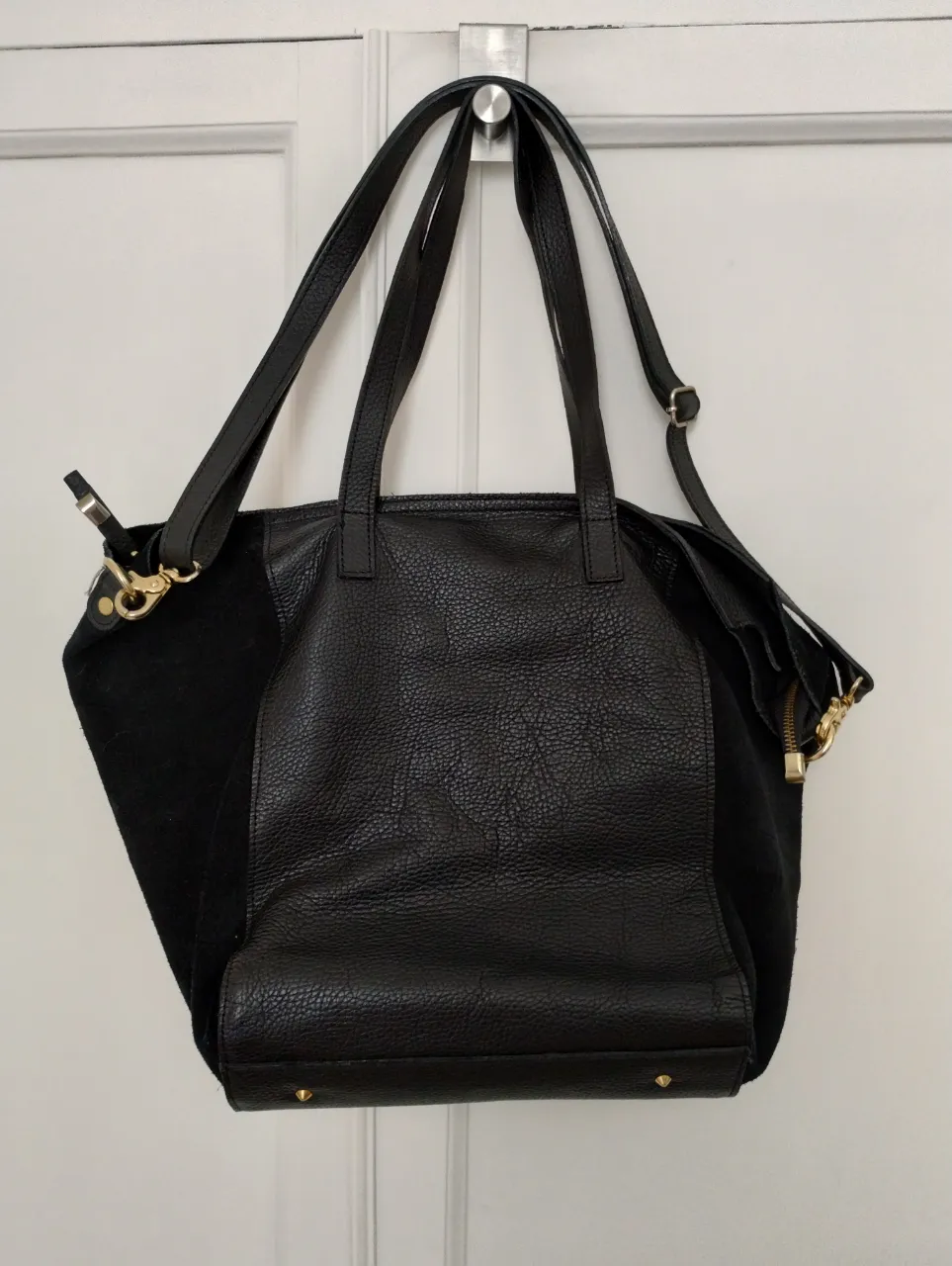 Bolso negro de cuero y gamuza, con detalles dorados. Tiene manijas cortas y una correa larga desmontable. Ideal para el día a día o para salir. aprox mide 40x50 