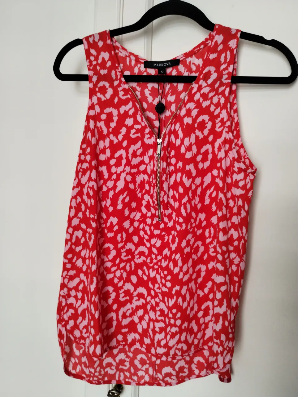 Musculosa roja con estampa animal print en blanco y rosa. talle 42. Posee un cierre metálico en el escote.