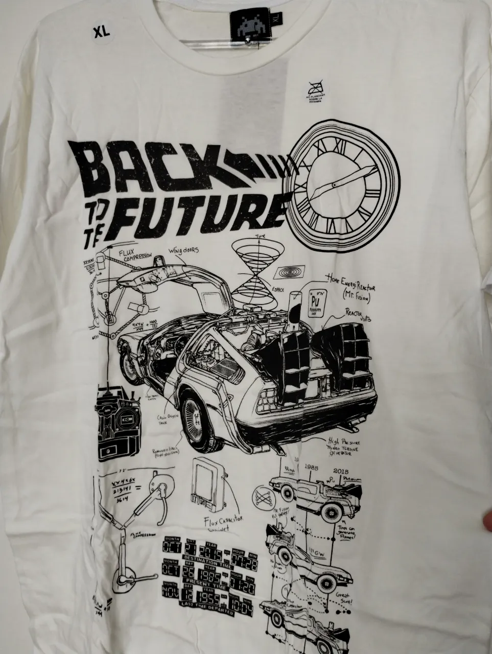 Remera blanca de "Back to the Future" con un diseño detallado del DeLorean y sus componentes. Ideal para fans de la película y para un look casual y retro.