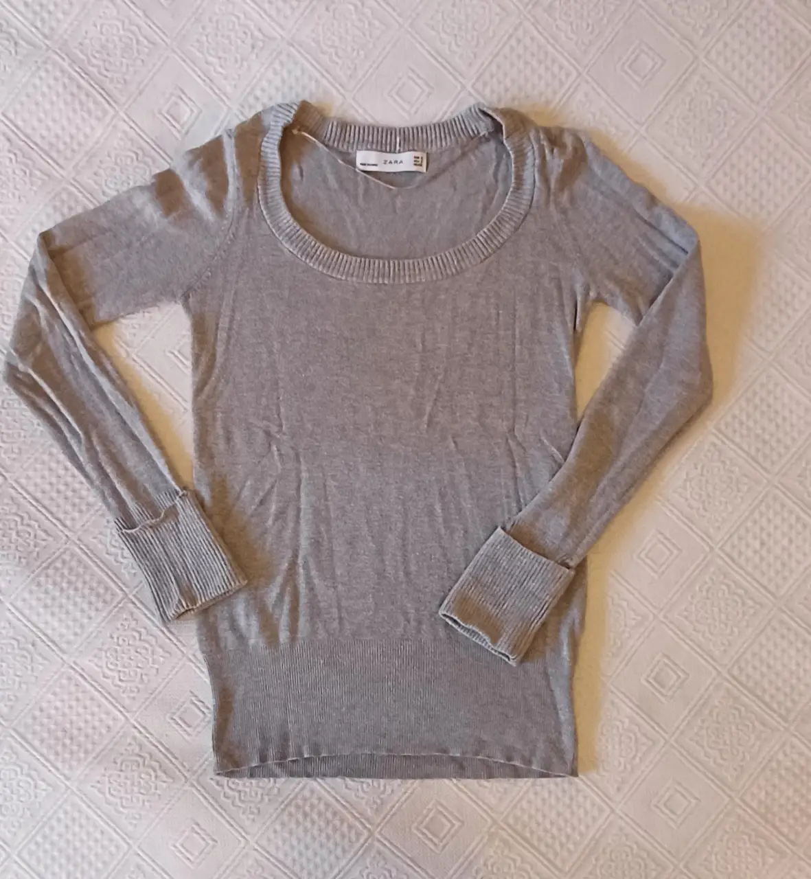 Sweater gris de manga larga con cuello redondo y puños acanalados. usado