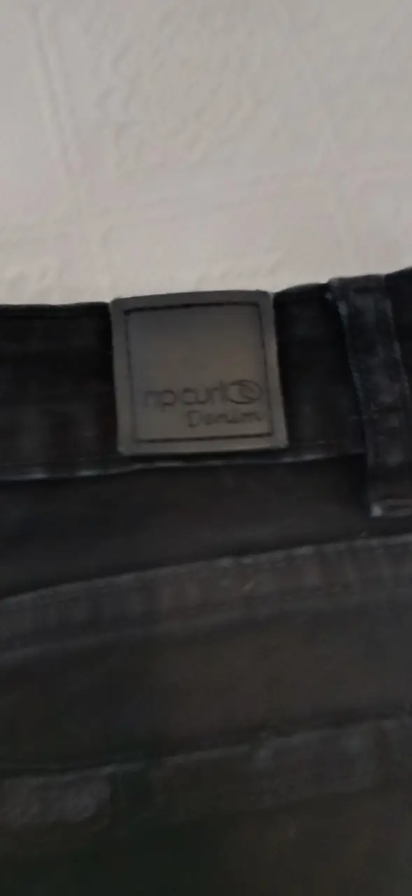 Short de jean negro de mujer, tiro alto, con detalles de roturas y flecos en el borde. Ideal para un look casual y moderno.