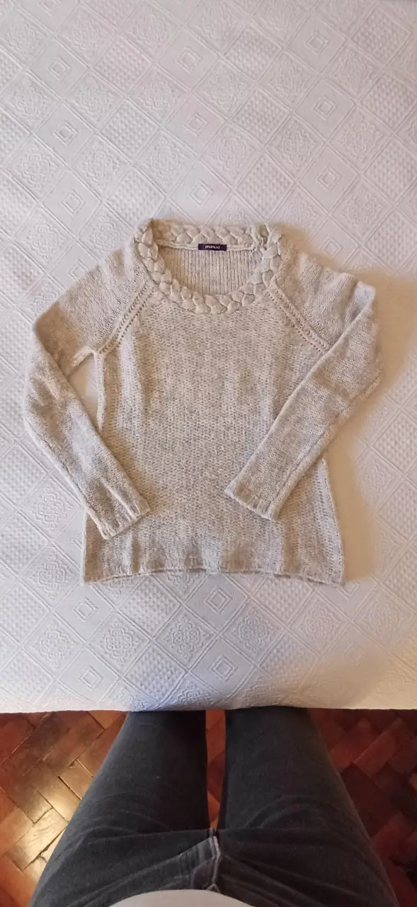 Sweater largo de mujer, color crudo, con detalle trenzado en el cuello. Ideal para un look casual y abrigado.