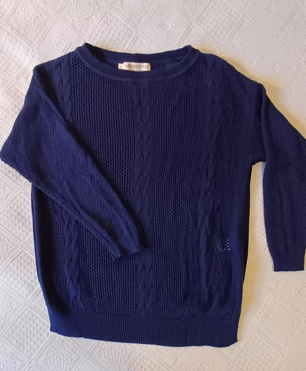 Sweater azul marino de punto con diseño trenzado en el frente. Cuello redondo y mangas 3/4. adelante es con punto traslucido y atrás no. 