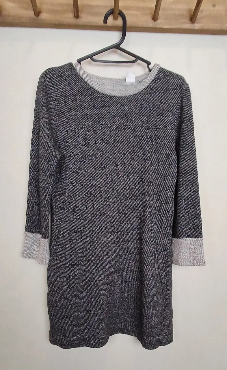 Sweater largo de tejido grueso en tonos grises y detalles en blanco. Ideal para un look casual y abrigado.