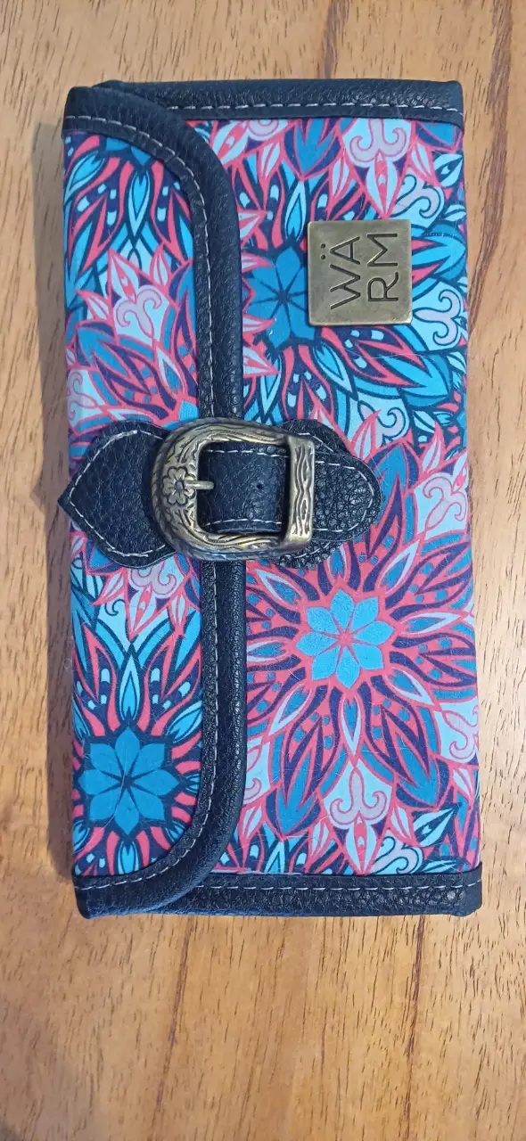 Billetera artesanal con diseño floral en tonos turquesa y coral. Cuenta con cierre y múltiples compartimentos internos. Ideal para organizar tus pertenencias con estilo.