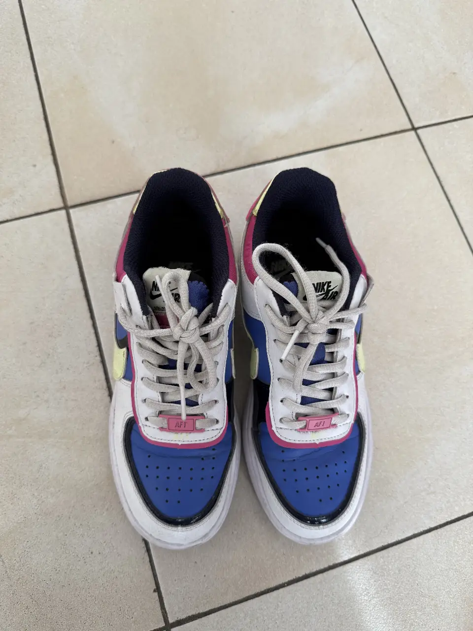 Zapatillas Nike Air Force 1 Shadow, con detalles en azul, rosa y amarillo. Ideales para un look casual y moderno.