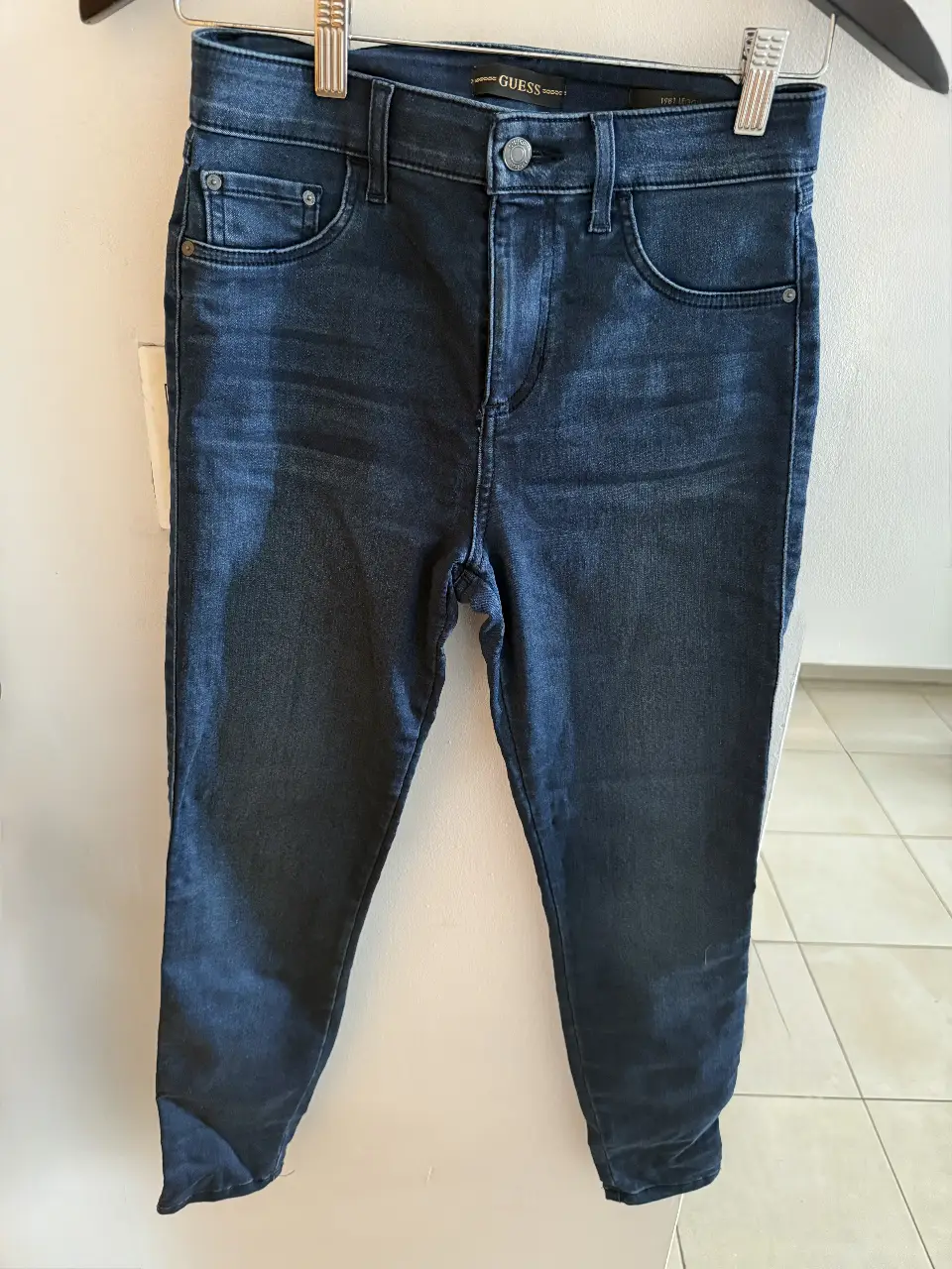 Jeans de mujer Guess tiro alto, color azul oscuro, ideal para un look casual y moderno. Calce perfecto y diseño clásico.
