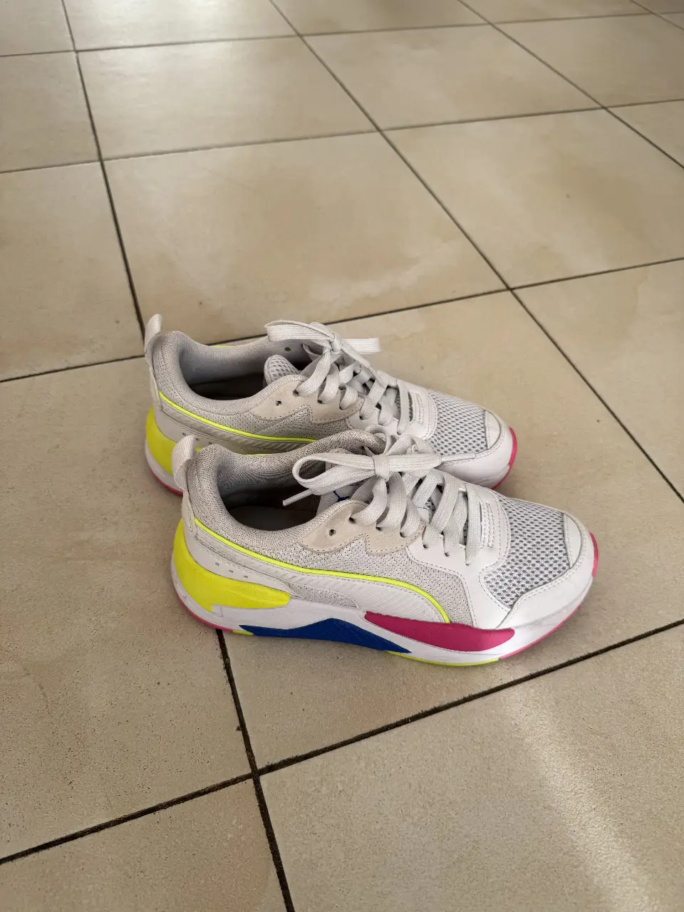 Zapatillas Puma X-Ray 2 Square, blancas con detalles en amarillo, rosa y azul. Ideales para un look deportivo y moderno.