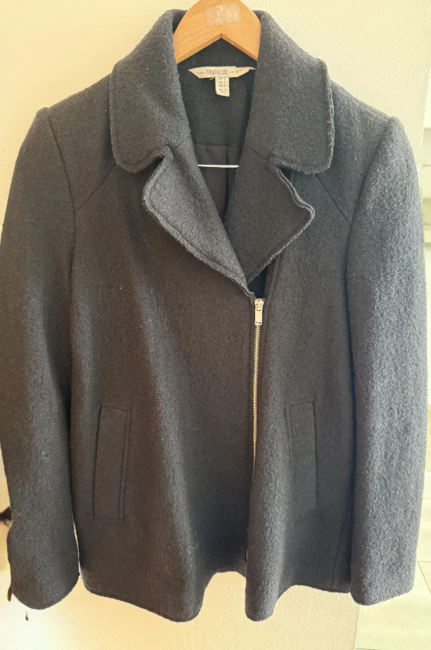 Campera negra de paño con cierre asimétrico y solapas. Ideal para un look moderno y abrigado.