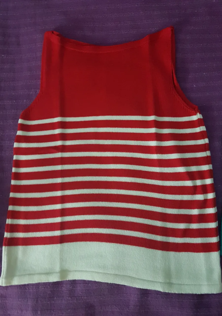 Musculosa a rayas rojas y blancas, con borde inferior blanco. Ideal para un look casual y fresco.