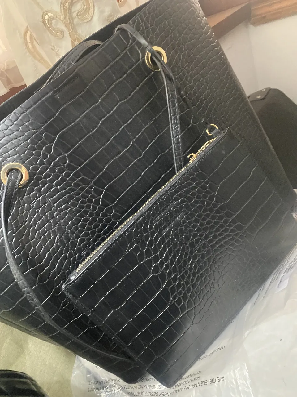 Cartera tote bag negra con diseño de reptil, incluye un sobre a juego. Ideal para llevar todo lo necesario con estilo y elegancia.