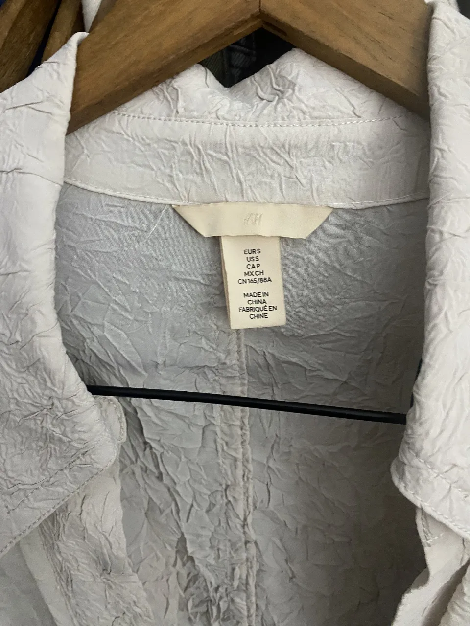 Camisa de mujer de la marca H&M, color crudo con textura arrugada. Talle S. Ideal para un look casual y cómodo.