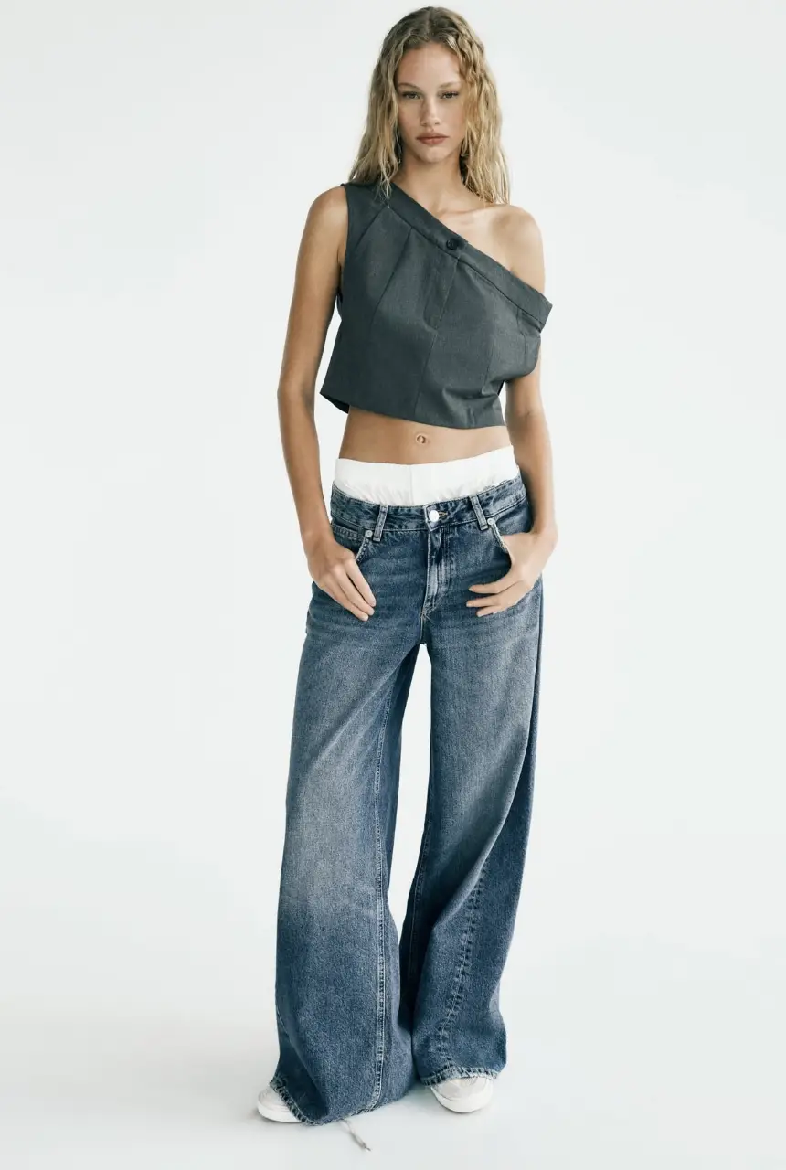 Top asimétrico de diseño moderno, confeccionado en tela gris. Ideal para un look sofisticado y a la moda.