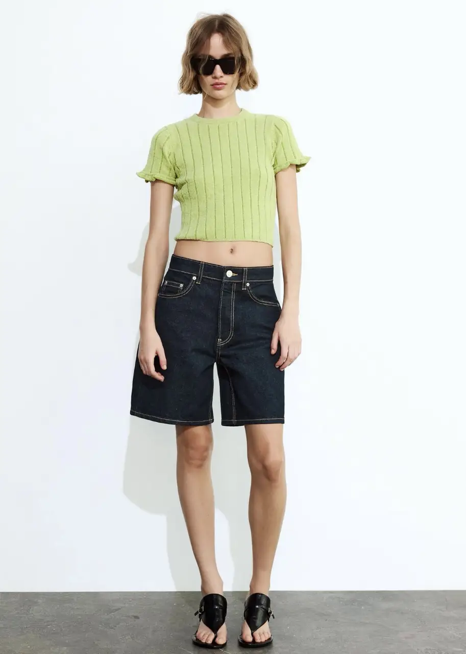 Top tejido de punto con mangas cortas con volados y corte crop. Ideal para un look fresco y moderno.