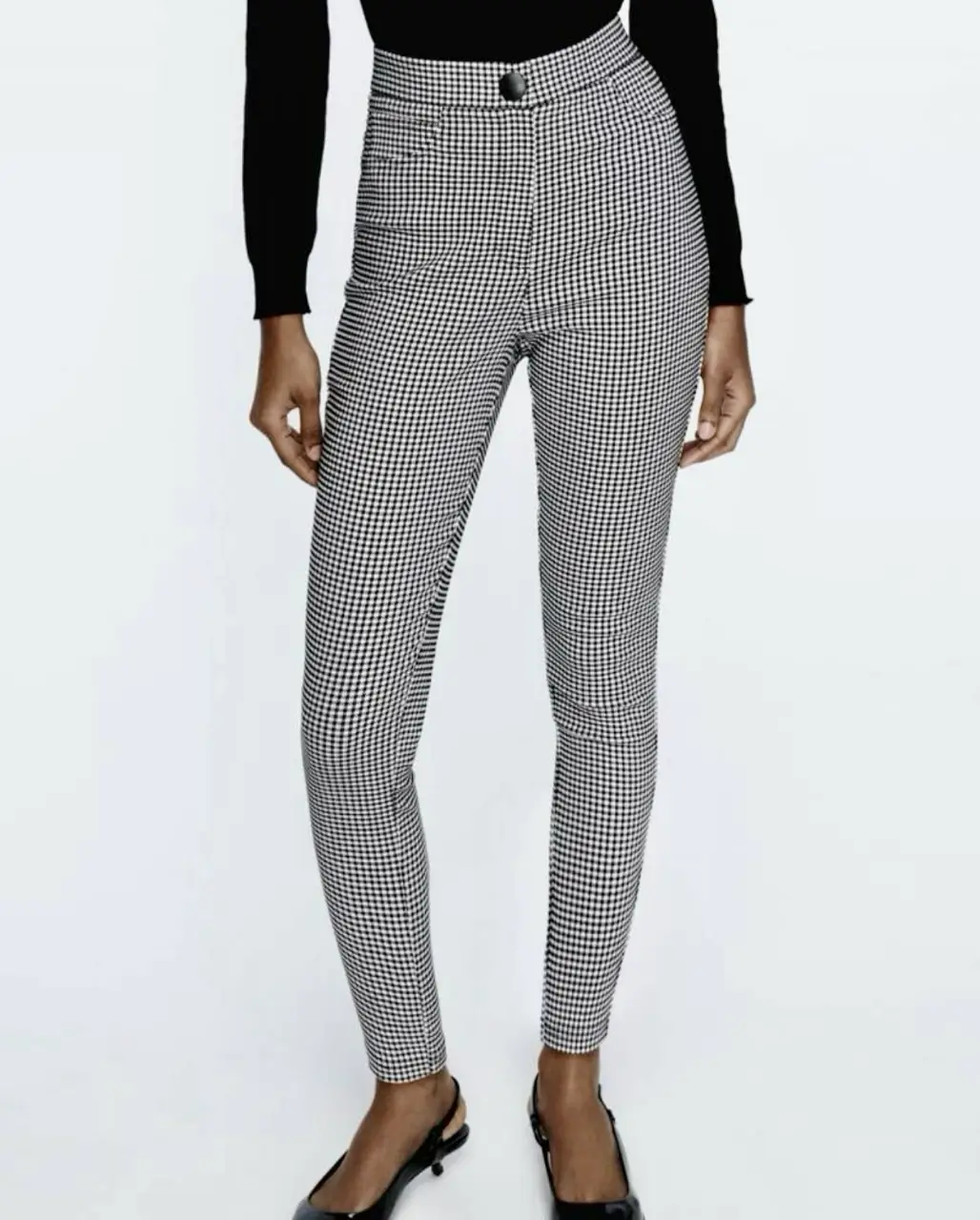 Pantalón sastrero de mujer con estampado de pata de gallo en blanco y negro. Tiro alto, con un botón y bolsillos delanteros. Ideal para un look elegante y moderno.