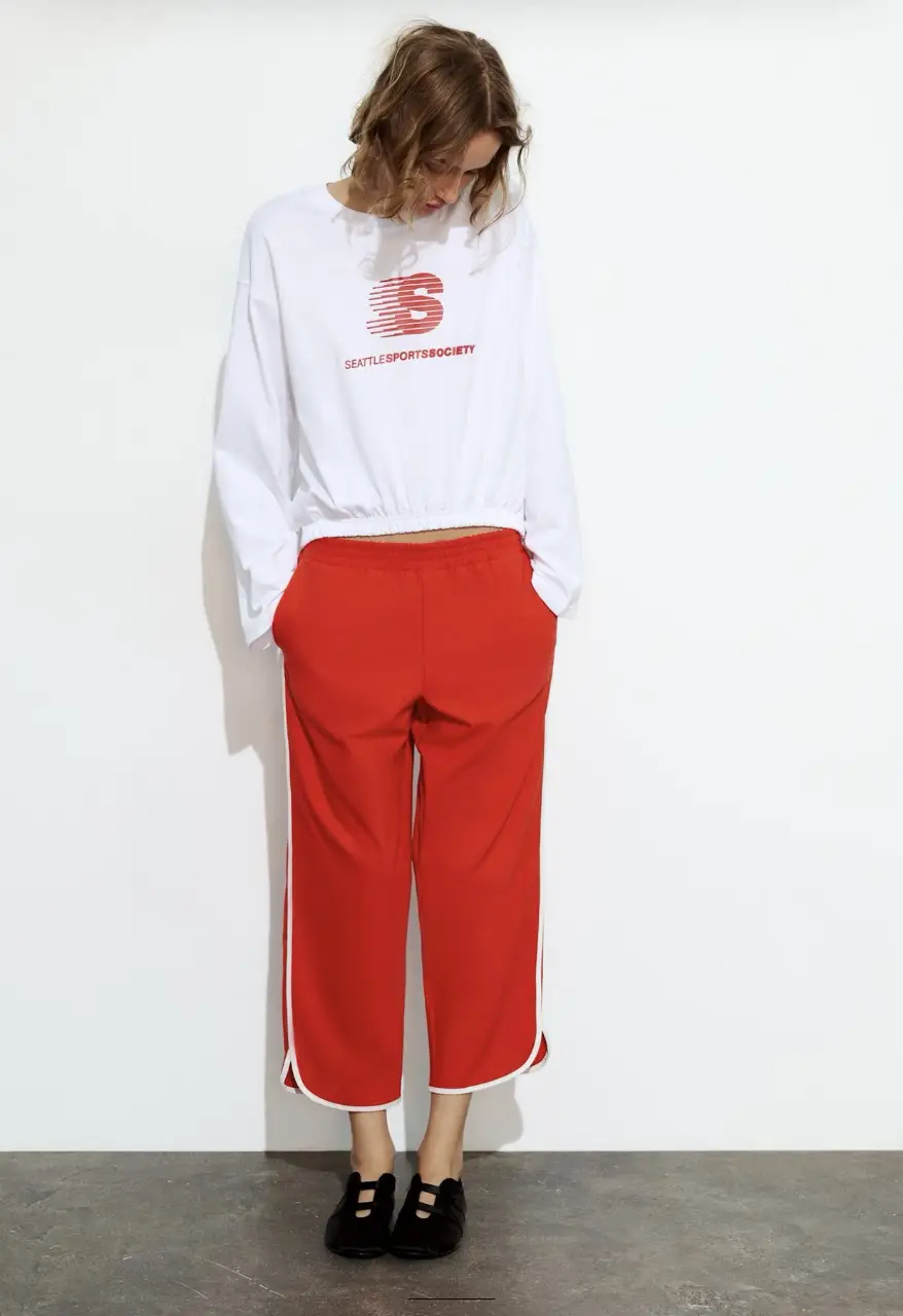 Pantalón deportivo rojo con detalles blancos en los laterales. Ideal para un look casual y cómodo.