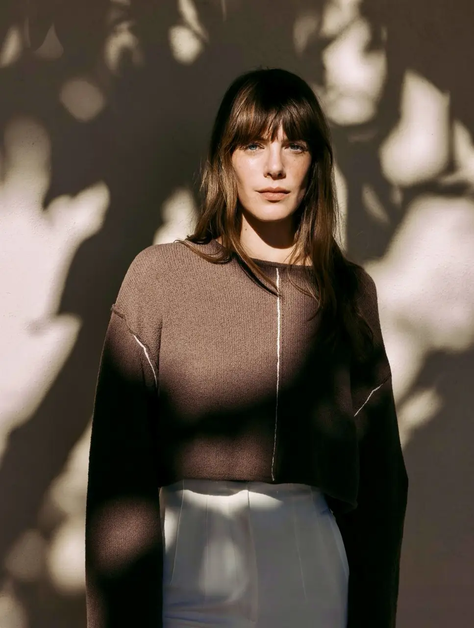 Sweater marrón de corte crop con detalle de costura blanca en el centro. Ideal para un look casual y moderno.