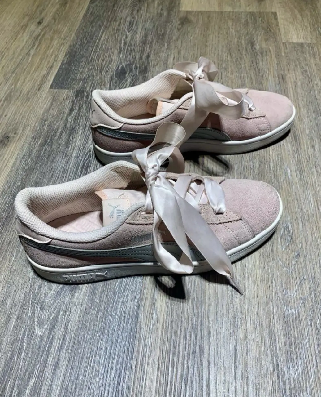 Zapatillas Puma rosas con cordones de cinta. Ideales para un look casual y femenino.