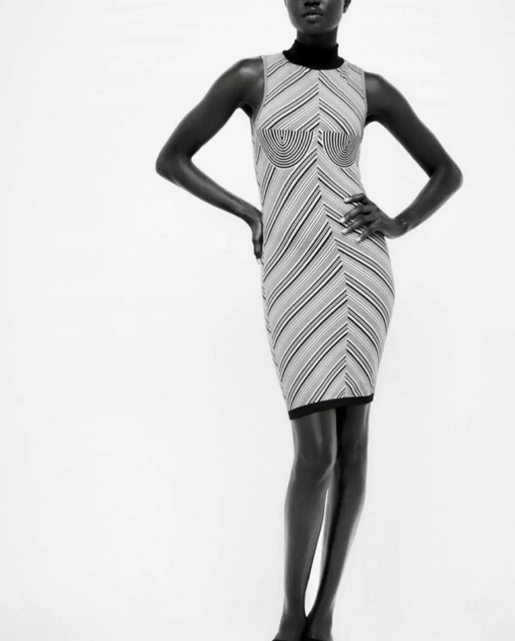 Vestido mini ajustado de punto con diseño de rayas en blanco y negro. Cuello alto y detalle de busto con forma.