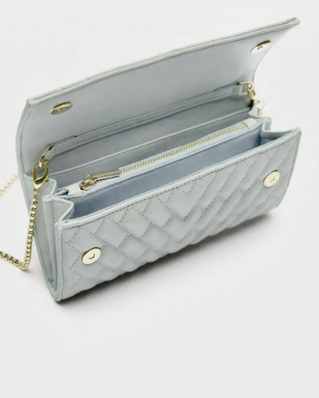 Cartera de mano acolchada en color celeste, con cadena dorada para llevar al hombro. Diseño elegante y versátil, ideal para complementar cualquier look.