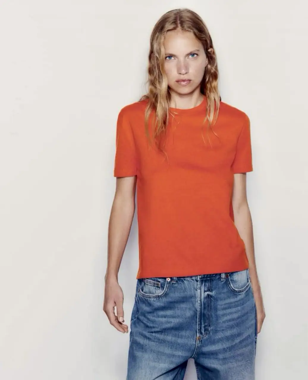 Remera naranja de manga corta, corte recto y cuello redondo. Ideal para un look casual y moderno.