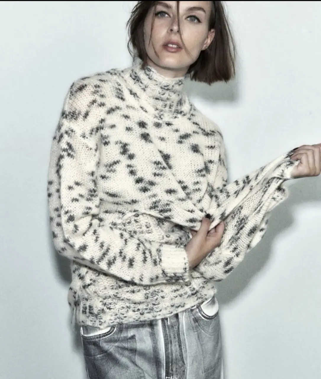 Sweater  de tejido grueso con estampado jaspeado en blanco y gris. Cuello redondo y diseño holgado. Ideal para un look casual y abrigado.