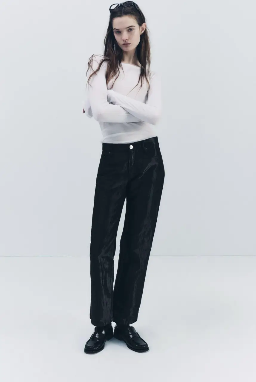 Pantalón negro corte Jean con efecto satinado. Tiro medio y corte recto. Ideal para un look elegante y moderno.