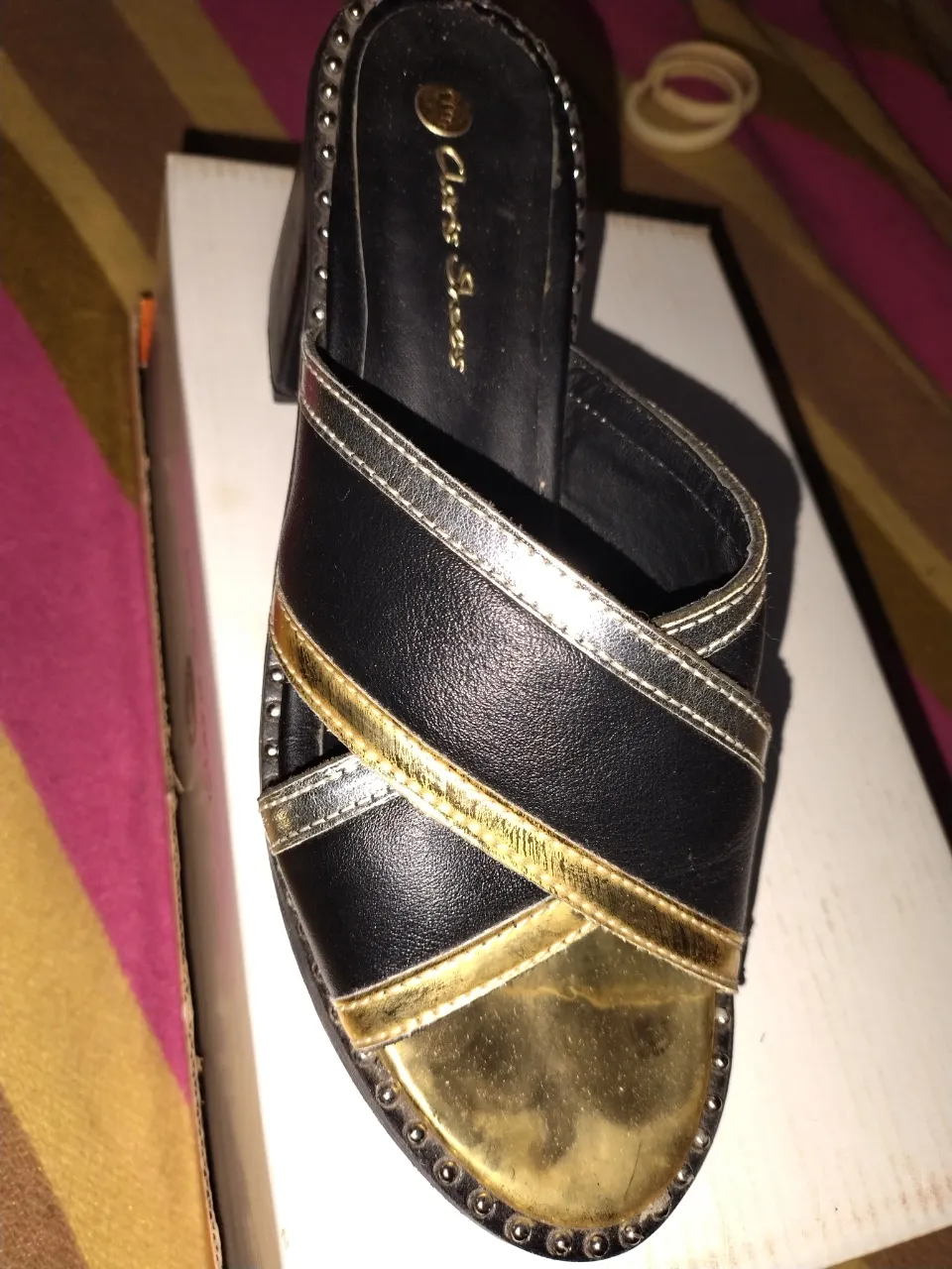 Sandalias de mujer negras con detalles dorados y plateados. Diseño cruzado y puntera dorada. Ideales para un look elegante y moderno.