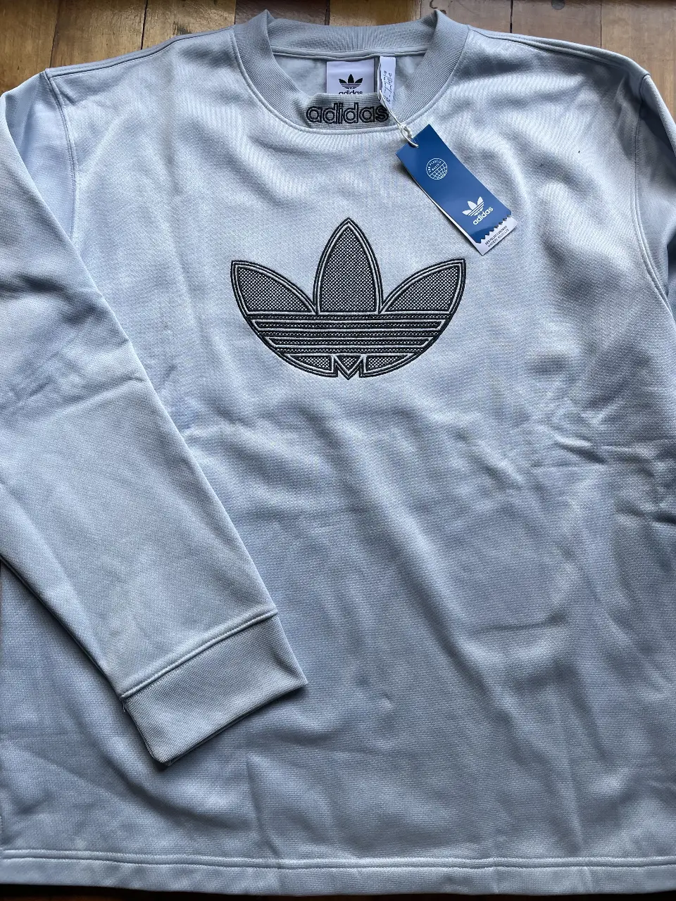 Buzo de cuello redondo Adidas Originals, unisex color celeste con el logo icónico de la marca en el frente.Ideal para un look casual y deportivo.