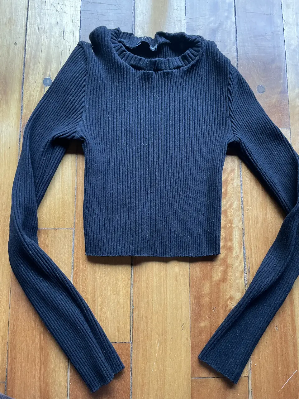 Sweater de cuello alto, tejido de punto acanalado, manga larga y corte crop. Ideal para un look moderno y versátil.
