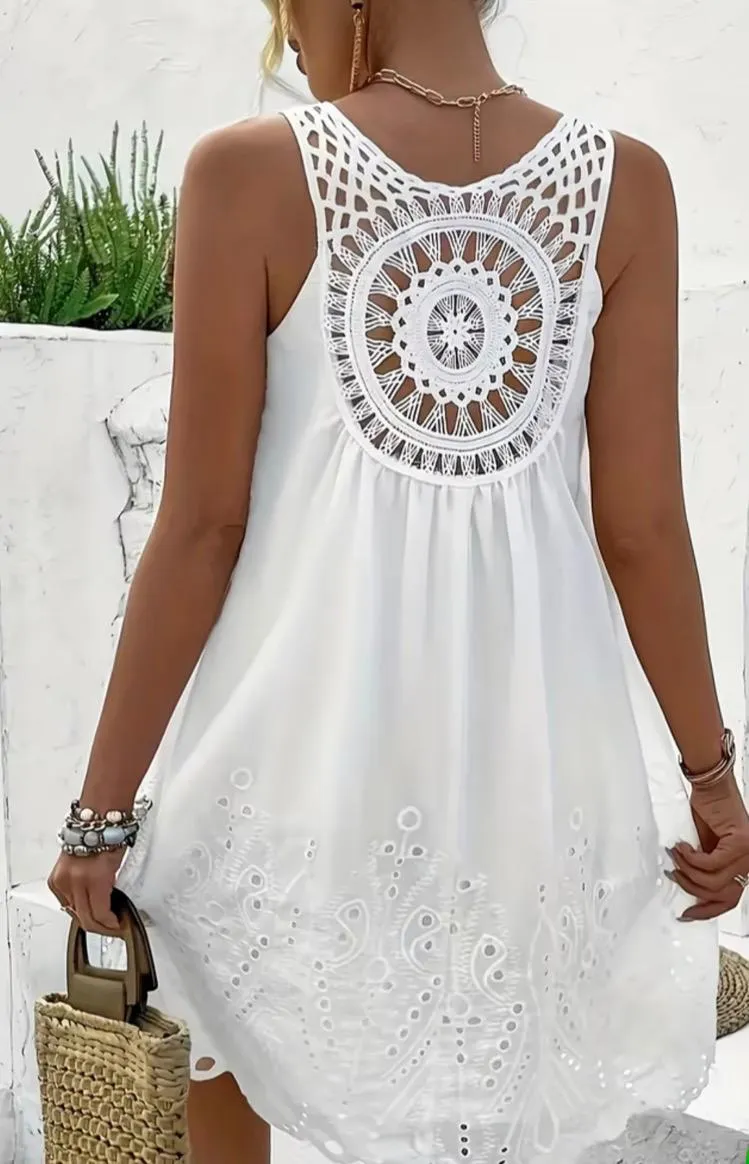 Vestido blanco corto con detalles de crochet en la espalda y bordados en el ruedo. Ideal para un look fresco y bohemio.