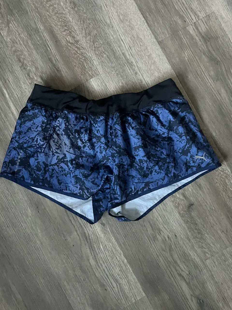 Short deportivo de mujer, con estampado en tonos azules y negros. Ideal para running y entrenamientos. Cuenta con cintura elastizada y un calce cómodo.
