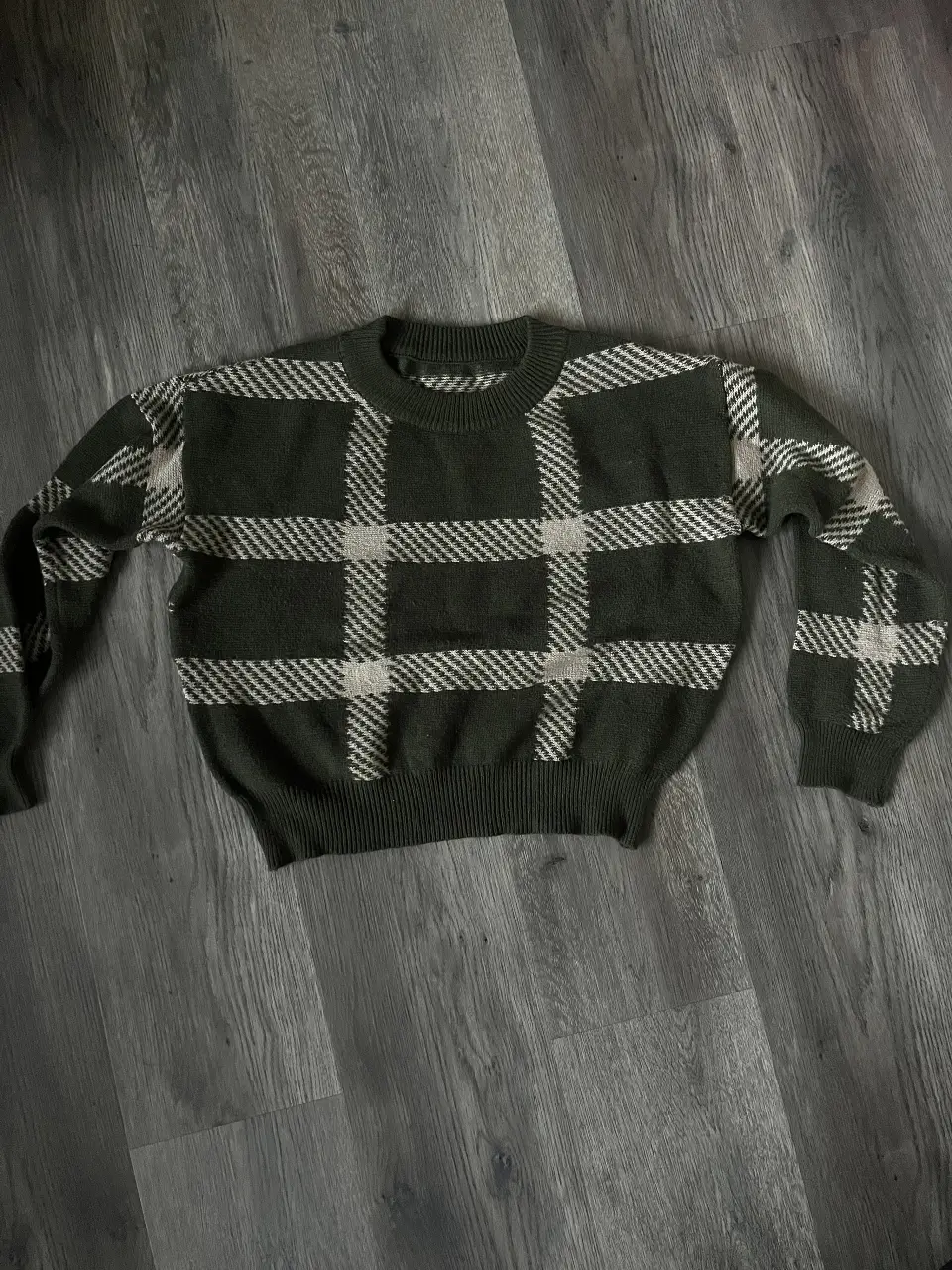 Sweater con diseño a cuadros en tonos verde oscuro y blanco. Ideal para un look casual y abrigado.