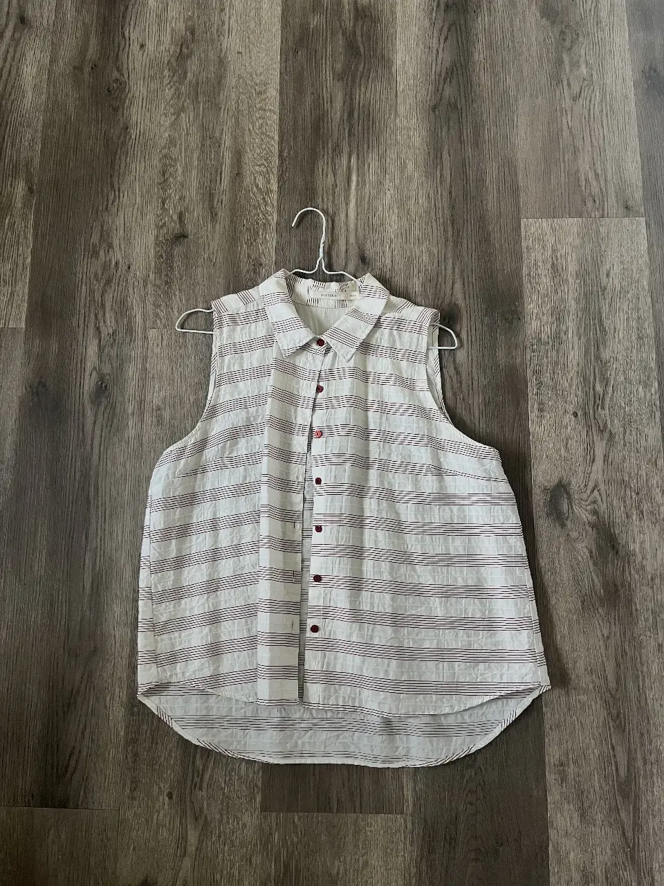 Camisa sin mangas a rayas horizontales en blanco y rojo. Cuello camisero y botones rojos. Marca PortsAId. Talle L/46.