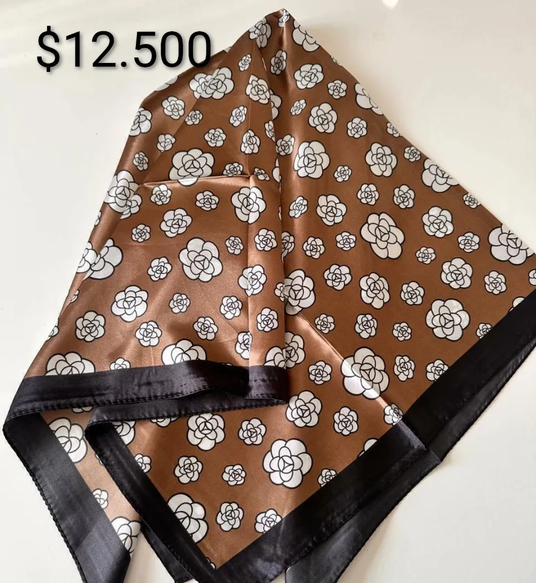 Pañuelo de seda con estampado floral y detalles de cadenas, ideal para darle un toque chic a tu outfit. Perfecto para usar en el cuello, en la cabeza o atado a tu cartera.