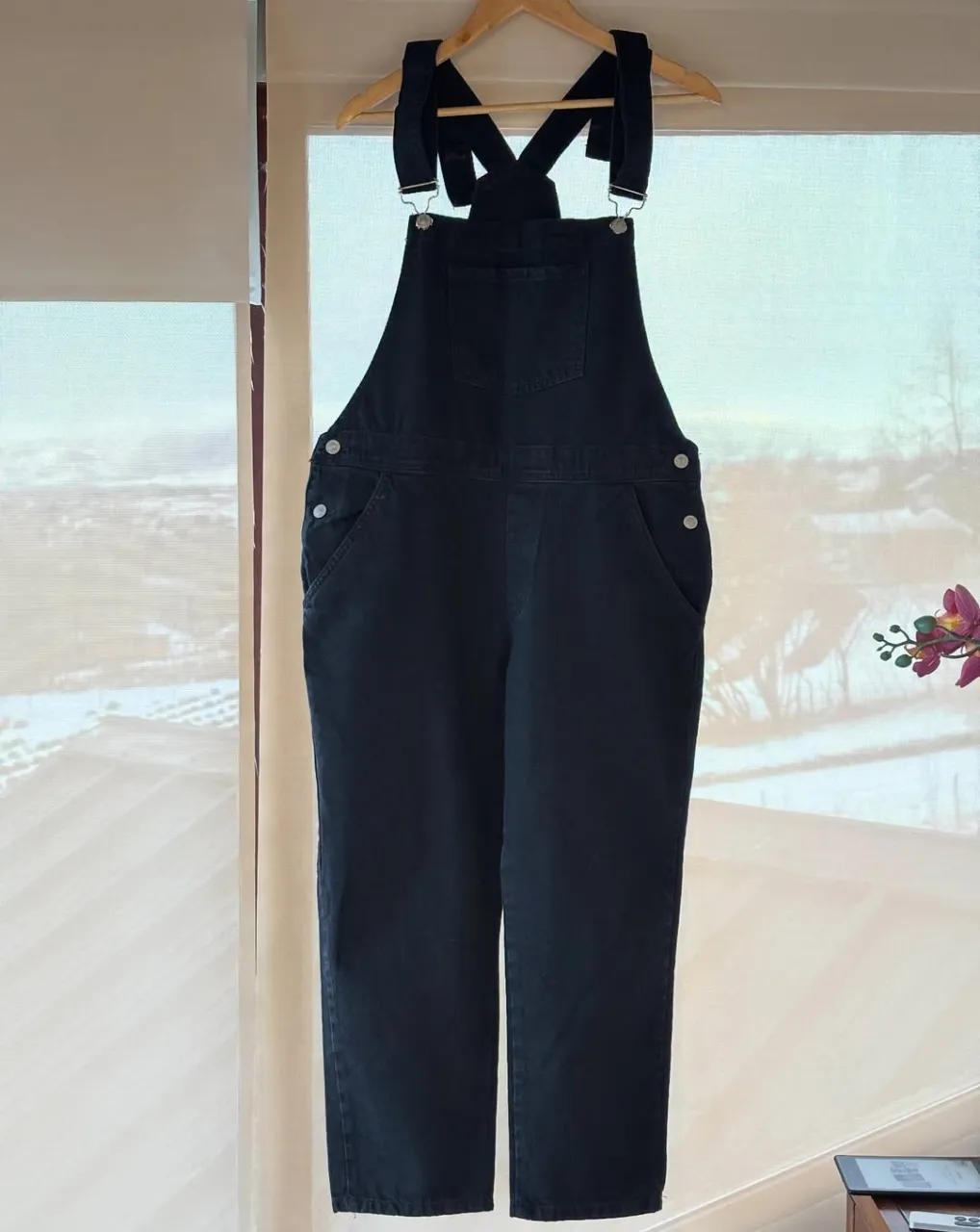 Overol de jean negro, tiro alto, con bolsillos delanteros y traseros. Ideal para un look casual y cómodo.