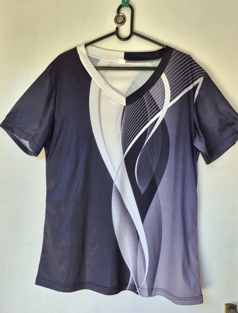 Remera con estampa abstracta en tonos oscuros y blancos. Diseño moderno y dinámico, ideal para  un look casual.
