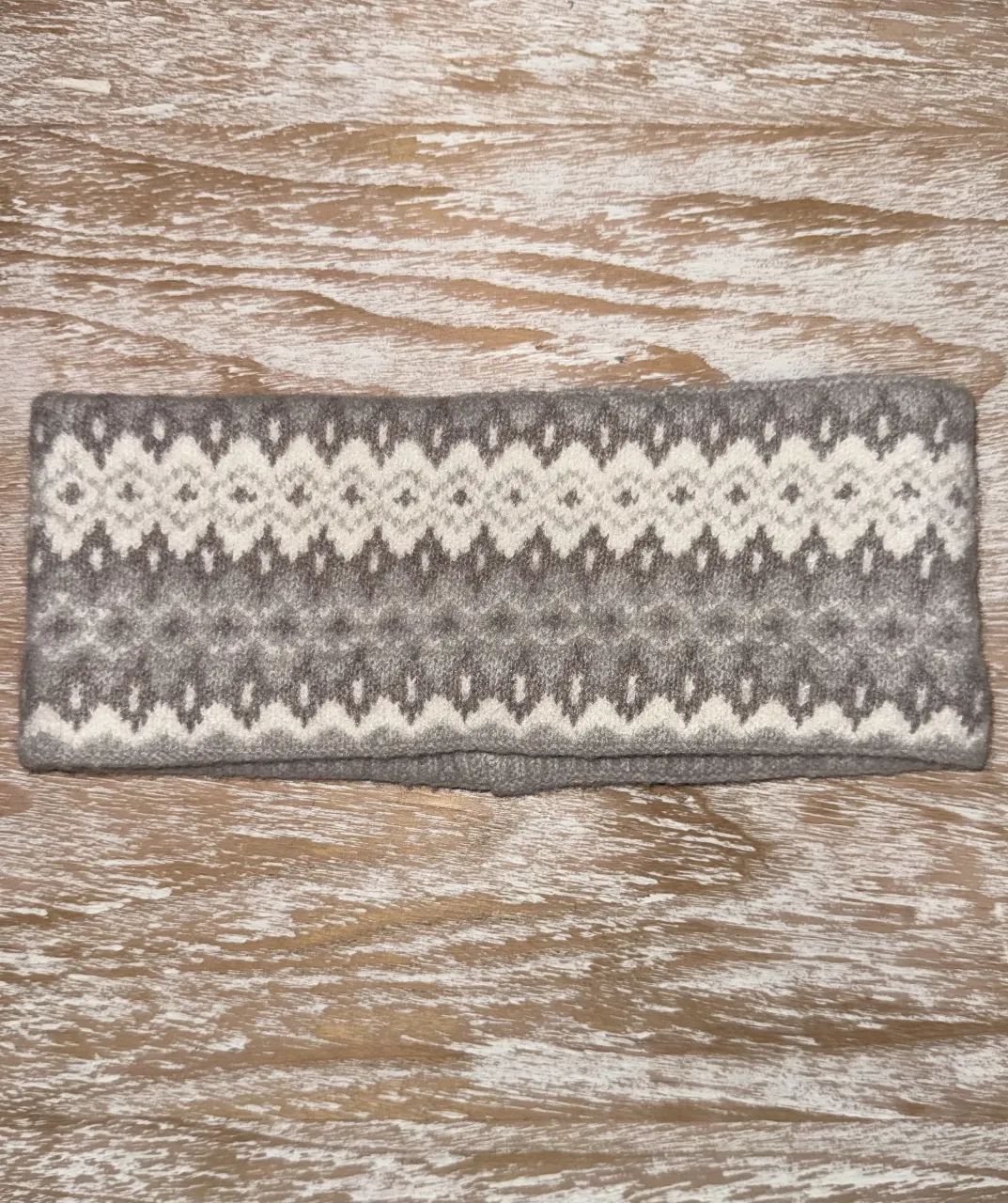 vincha de lana tejida con diseño geométrico en tonos grises y blanco. Ideal para abrigar y complementar cualquier look de invierno. Sin usar