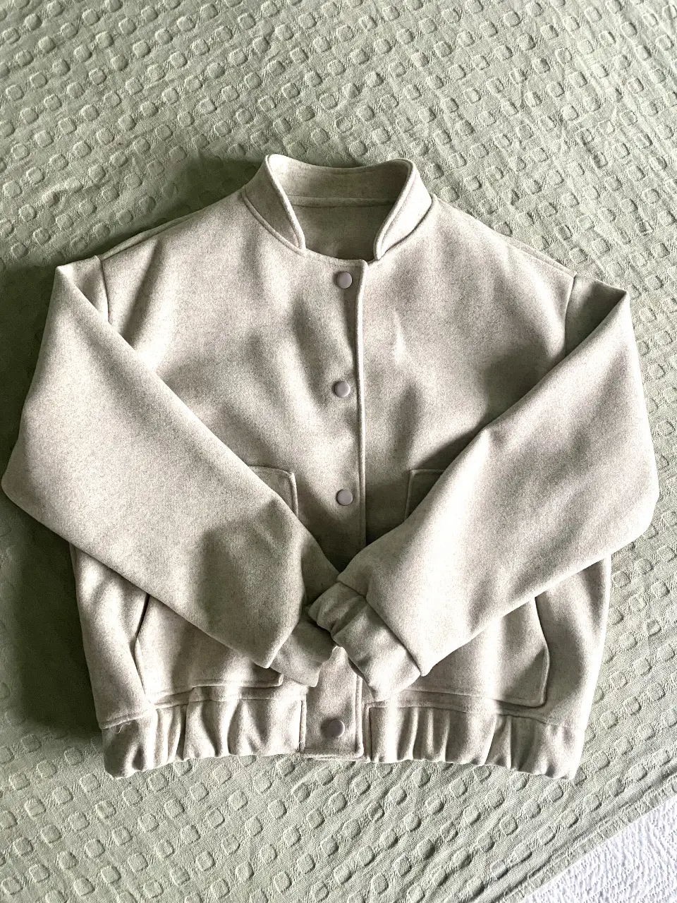 Campera bomber de mujer, color gris claro. Confeccionada en paño, ideal para un look casual y abrigado. Posee bolsillos laterales y cierre con botones. Medidas Siza 60 cm, largo de  mangas 55 cm, largo total 60 cm. Esta nueva, me la dieron pero no es mi estilo.