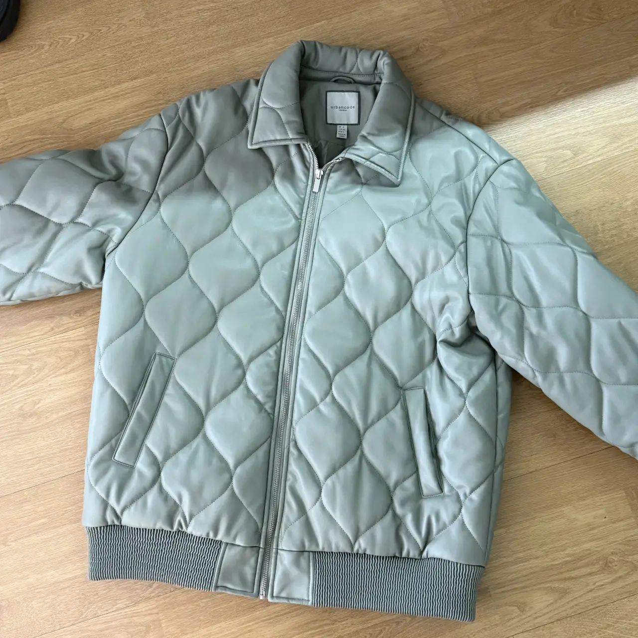 Campera bomber acolchada de simil cuero en color verde claro. Posee cierre frontal y bolsillos laterales. Ideal para un look casual y moderno.