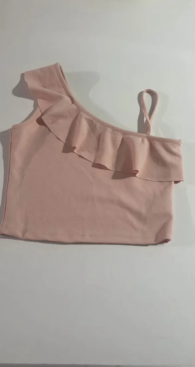 Top rosa de un solo hombro con volado.