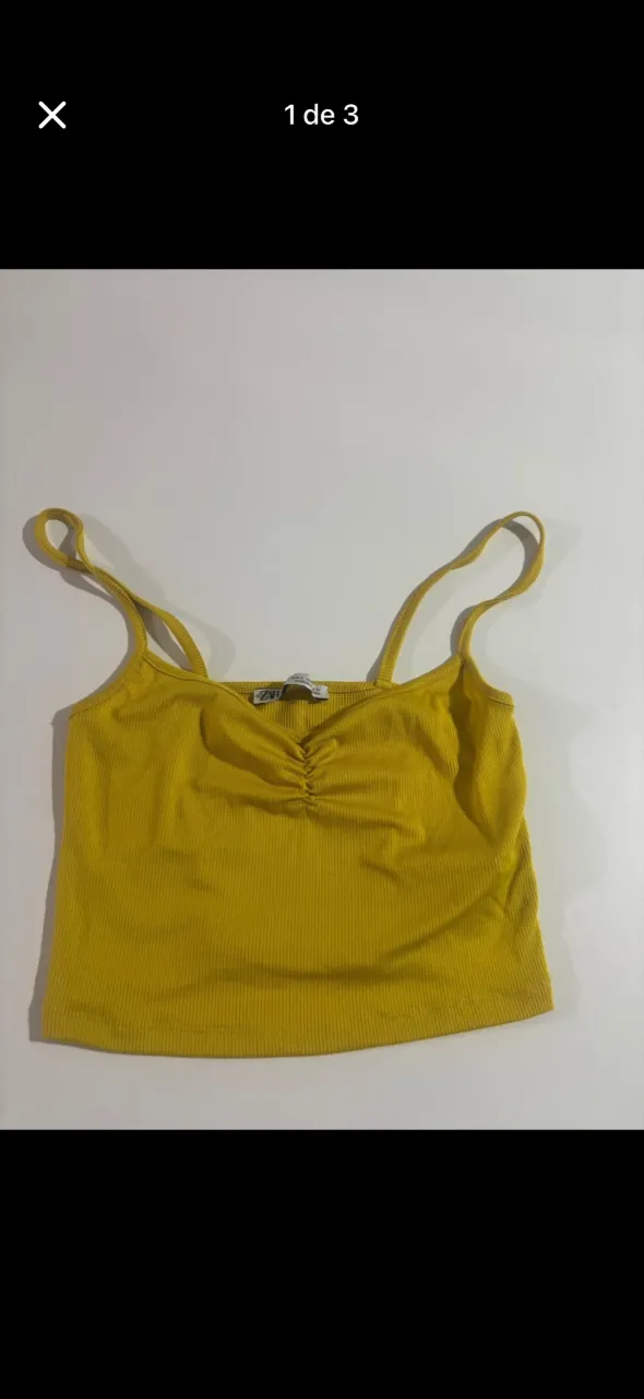 Top amarillo con tiras finas y detalle fruncido en el frente. Tejido acanalado.