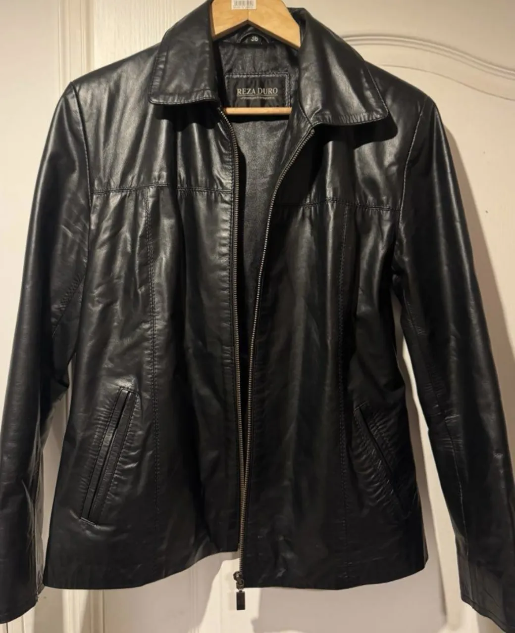 Campera de cuero negra con cierre al frente y bolsillos laterales.