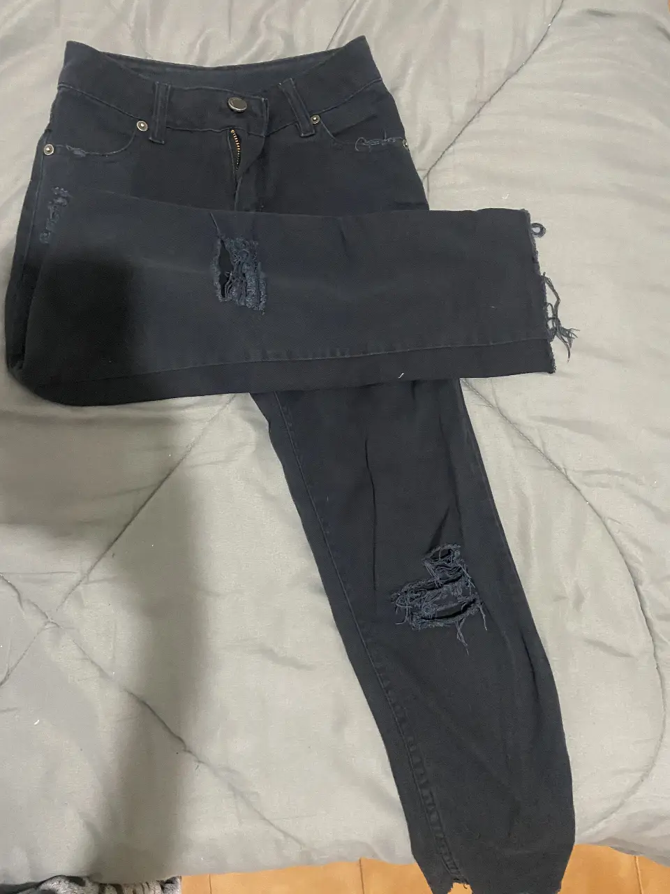 Jeans negro con roturas, tiro medio y corte recto. Un clásico para cualquier ocasión.