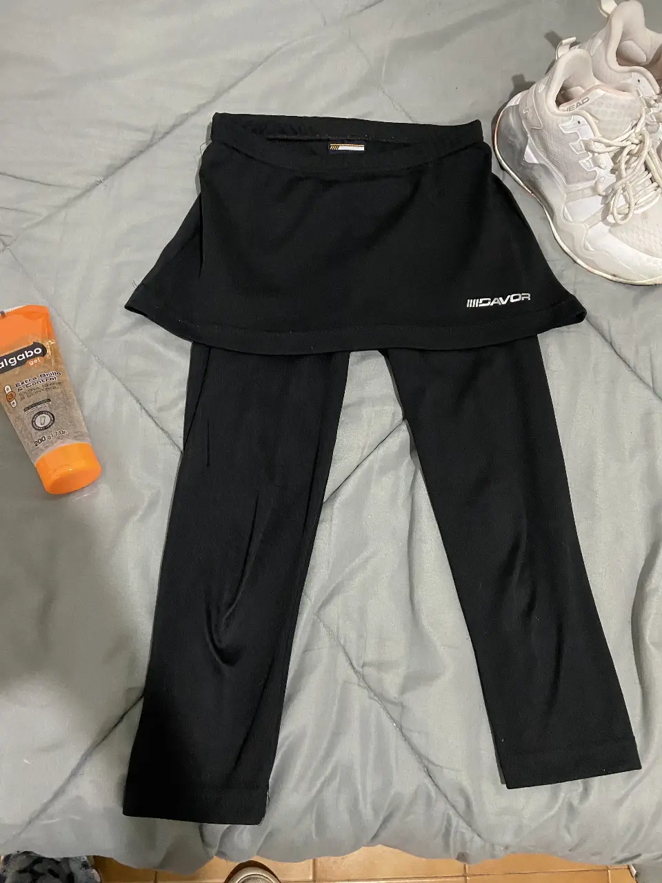 Calza deportiva negra con falda incorporada, ideal para actividades físicas. Diseño funcional y cómodo para un look deportivo.