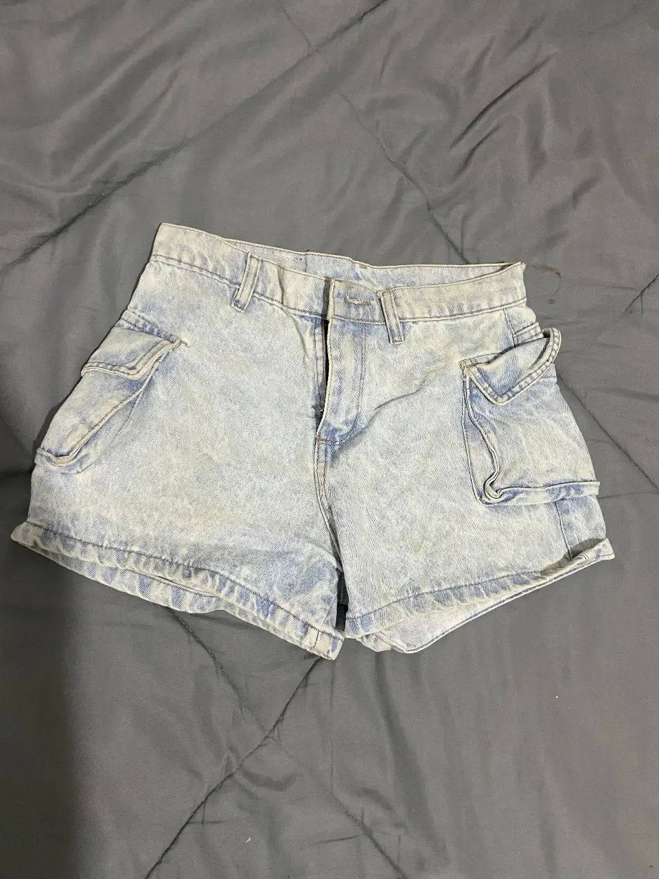 Short de jean de mujer, tiro alto, con bolsillos cargo laterales. Ideal para un look casual y moderno.