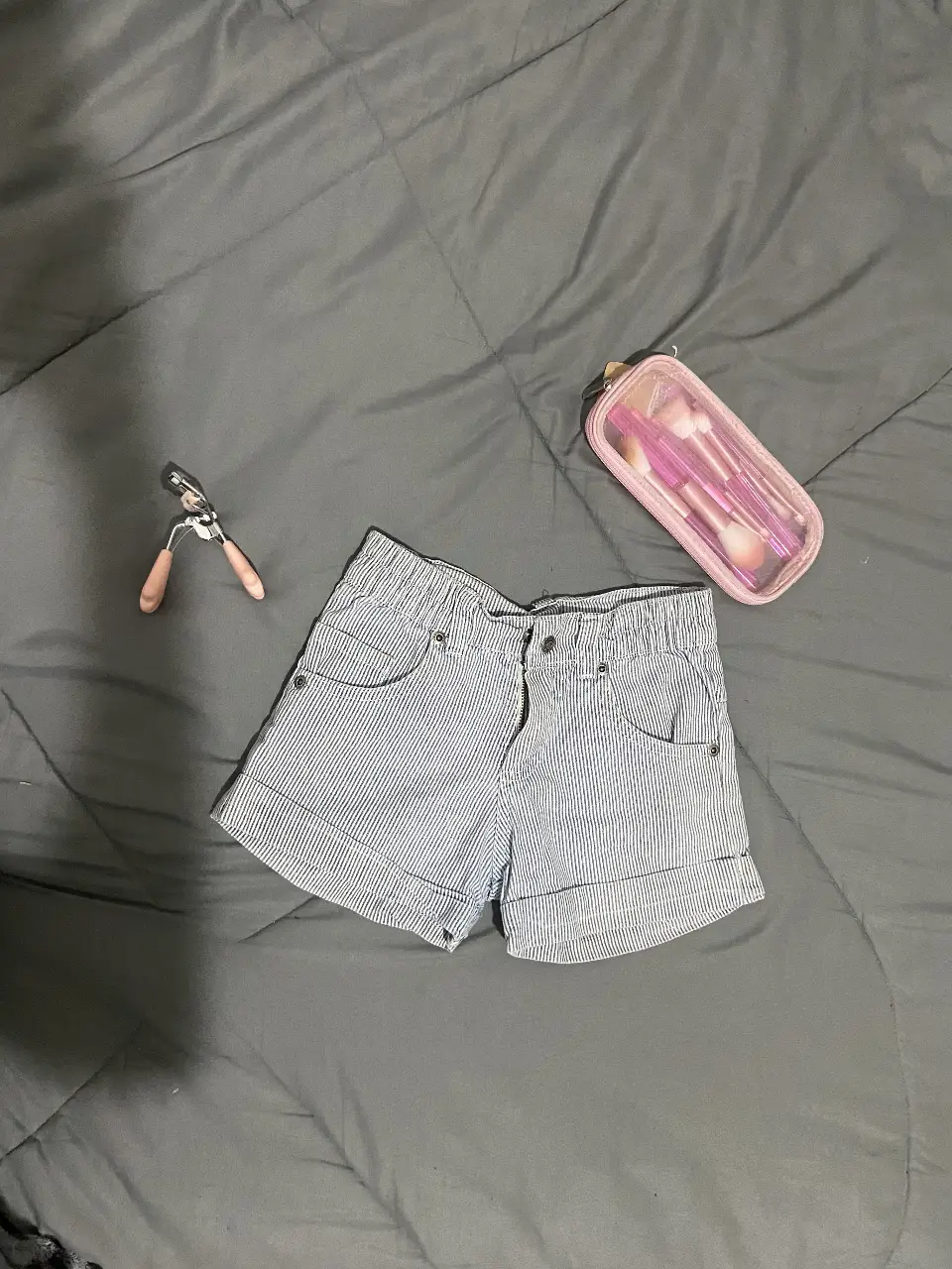 Short de jean a rayas celeste y blanco, tiro medio, con bolsillos delanteros y traseros. Ideal para un look casual y fresco.