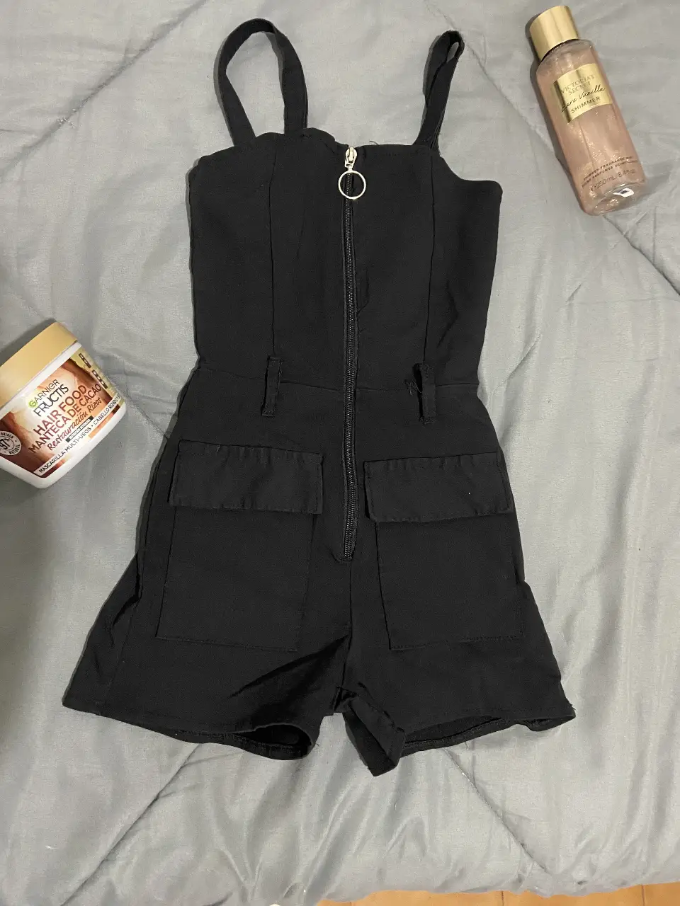Mono corto negro con cierre frontal y bolsillos delanteros. Ideal para un look casual y moderno.